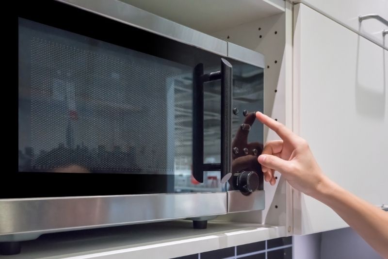 a hand touching a microwave in Newcastle